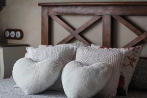 1 cama con 2 almohadas blancas y cabecero de madera en casa rural La picotina, en Navaconcejo