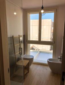 a bathroom with a tub and a chair and a window at Casa Rita in Brescia