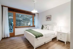 ein Schlafzimmer mit einem weißen Bett und einem Fenster in der Unterkunft Isabella Apartment by Quokka 360 - with a lake view on the Melide bridge in Melide