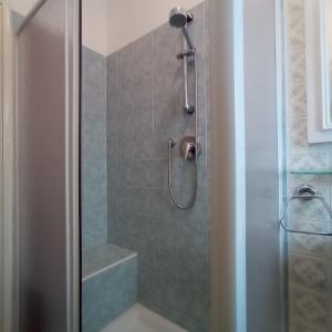 La salle de bains est pourvue d'une douche avec une porte en verre. dans l'établissement Appartamento Viale della Repubblica, à Pietra Ligure