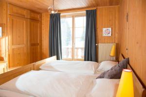 a bedroom with two white beds and a window at Residence for 12 persons Chalet Crestas-Lenzerheide in Lenzerheide