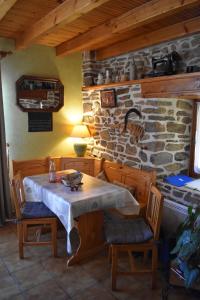 Una mesa y sillas en una habitación con una pared de piedra. en Au bon Accueil anciennement Le Jardin fleuri, en Bonnac