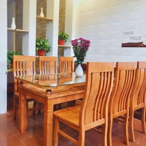 a dining room table with wooden chairs and a glass top at Đức Tuân 2 Motel in Hai Phong