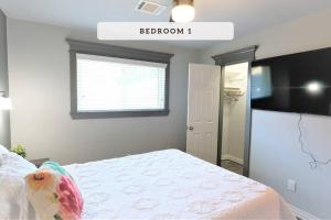 een slaapkamer met een bed, een raam en een televisie bij NRG, Medical Center, Galleria, Energy Corridor, MD Anderson - 15206 in Missouri City