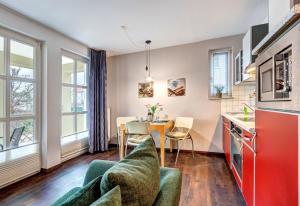 班辛海的住宿－Villa Margot - FeWo 02，一间厨房、带桌椅的客厅和一间配有红色