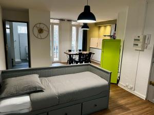 Il comprend une chambre avec un lit et une cuisine équipée d'un réfrigérateur vert. dans l'établissement Appartements Rue des Jardins, à Perpignan