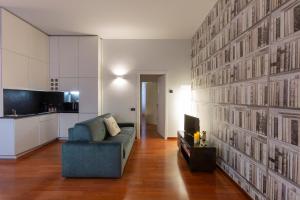 Il comprend un salon avec un canapé bleu et une cuisine. dans l'établissement My Charming Apartments in Centro Città-San Lorenzo Suite, à Milan