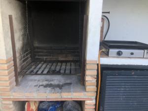 an open door of a building with a grill at Los Algarrobos Gaucin in Gaucín