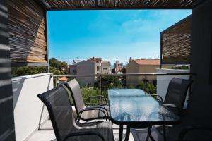 een tafel en stoelen op een balkon met uitzicht bij Octo Villas Complex in Iraklitsa