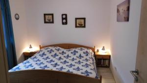 1 dormitorio con 1 cama con manta azul y blanca en Wohnung nahe Heidepark & Serengetipark, en Bergen