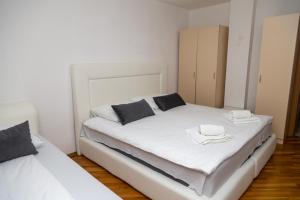 Una cama blanca con dos toallas encima. en Grand Lux Apartmani Pale, en Pale