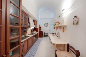 cocina grande con 2 lavabos y mesa en Villa 4 Colonne, Capri, en Capri