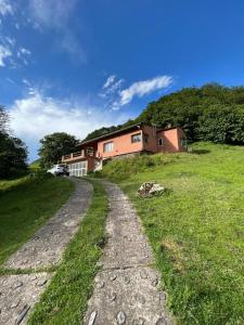 una casa en una colina con un camino de tierra en Casa de Montaña en La Angostura