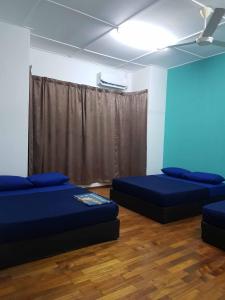 Cette chambre comprend deux lits et un ventilateur de plafond. dans l'établissement 4 Bedroom House Indera Mahkota 8 Kuantan Homestay, à Kuantan