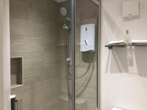een douche in een badkamer met een glazen deur bij Garden Studio in Benson