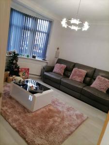 a living room with a couch and a coffee table at Grand 4 Bed 3 Bath House Chadwell Heath, Romford, London in Goodmayes