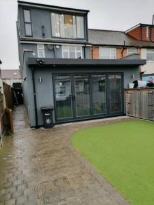 a house with a green lawn in front of it at Grand 4 Bed 3 Bath House Chadwell Heath, Romford, London in Goodmayes