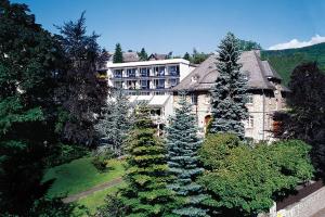 a large building in the middle of a forest of trees at Rüters Parkhotel in Willingen