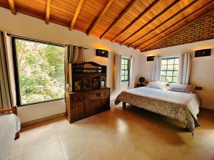伦索伊斯Casa Lipe & Rafa Linda casa com árvores的一间带床和大窗户的卧室