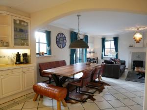 a kitchen and living room with a wooden table and chairs at Villa Buiten 130 met Sauna in Callantsoog