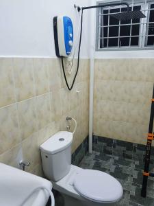 La salle de bains est pourvue d'une douche et de toilettes. dans l'établissement 4 Bedroom House Indera Mahkota 8 Kuantan Homestay, à Kuantan