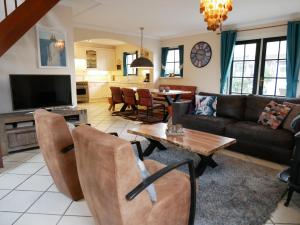 a living room with a couch and a table at Villa Buiten 130 met Sauna in Callantsoog