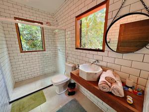 伦索伊斯Casa Lipe & Rafa Linda casa com árvores的带水槽、马桶和镜子的浴室