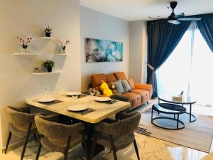 a living room with a table and chairs and a couch at Lumi Tropicana, PJ-02, Golf View in Petaling Jaya