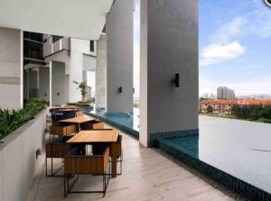 a balcony with tables and a view of a city at Lumi Tropicana, PJ-02, Golf View in Petaling Jaya