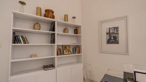 ein weißes Bücherregal in einem Zimmer mit Büchern in der Unterkunft Aureliana Apartments in Rom