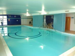 uma grande piscina com água azul num edifício em Spacious 2 Bed Perfect for City Centre & Bay, Pool, Gym em Cardiff
