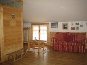 sala de estar con sofá rojo y mesa en B&B Al Calicanto, en Sorisole