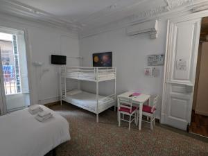 バルセロナにあるHostal del Palauのベッドルーム1室(二段ベッド1組、テーブル、デスク付)