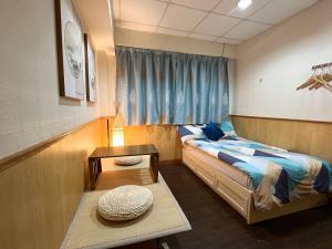 a small bedroom with a bed and a table at 利園賓館 in Hong Kong