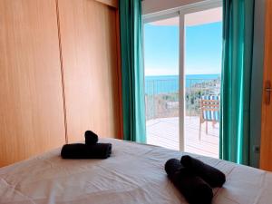 een slaapkamer met een bed met twee zwarte kussens en een raam bij Appartement Cala Merced El Campello in El Campello