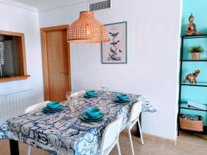 een eettafel met een blauw en wit tafelkleed bij Appartement Cala Merced El Campello in El Campello
