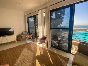 uma sala de estar com uma grande janela com vista para o oceano em Silafando apartment - ecofriendly oceanview em Bijilo