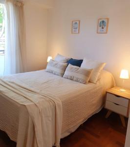 1 dormitorio con 1 cama con sábanas blancas y ventana en Depto MDQ en Mar del Plata