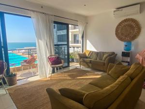 a living room with a couch and a view of the ocean at Silafando apartment - ecofriendly oceanview in Bijilo