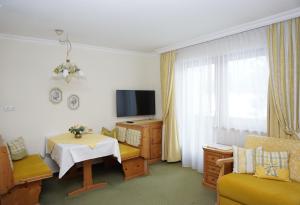 a small living room with a table and a television at Landhaus Achental in Pertisau