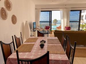 uma sala de jantar com mesas e cadeiras com vista em Silafando apartment - ecofriendly oceanview em Bijilo