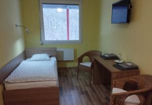 Cette chambre comprend un lit, un bureau et une fenêtre. dans l'établissement GAS Truck centrum, à Holíč