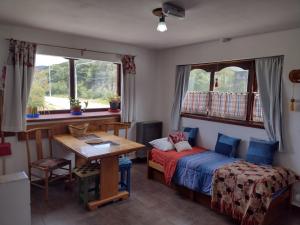 1 dormitorio con cama, mesa y ventana en El Rincón del Andino Planta Alta en Ushuaia