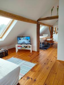 a room with a bed and a tv in a attic at Schlaf mal im Denkmal in Birstein