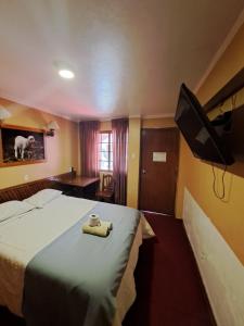 Habitación de hotel con cama y TV de pantalla plana. en Hotel la casona, en Huaraz