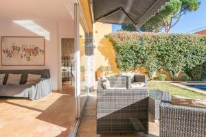 a living room with a couch and an umbrella at CASA TARONGERS - pool, beach, quiet in Palafrugell