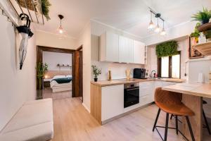 a kitchen with white cabinets and a table and chairs at City Center Studio Apartment for Humans & Pets - One in Rijeka