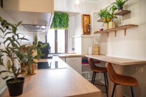 a kitchen with a table and chairs and plants at City Center Studio Apartment for Humans & Pets - One in Rijeka