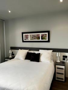 a bedroom with a large white bed with two lamps at Apartamento - Riba De Sella in Ribadesella