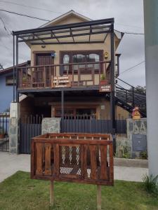 a house with a deck with a fence in front of it at El Rincón del Andino - Planta Baja in Ushuaia